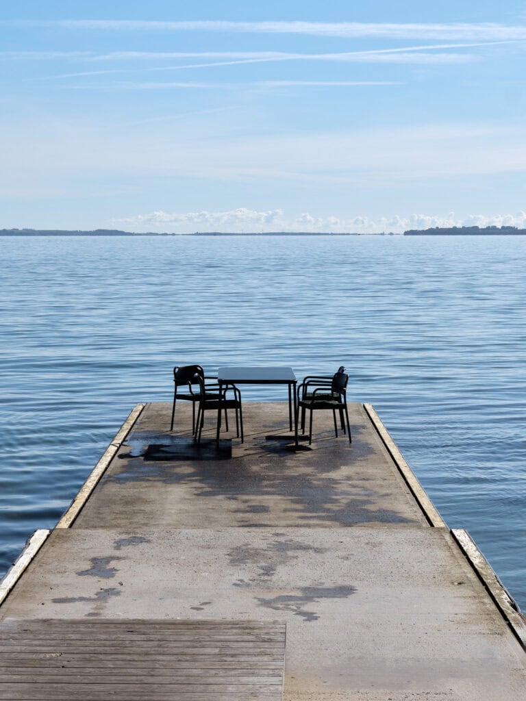 Conjunto de sillas y mesas Vind en el mar.