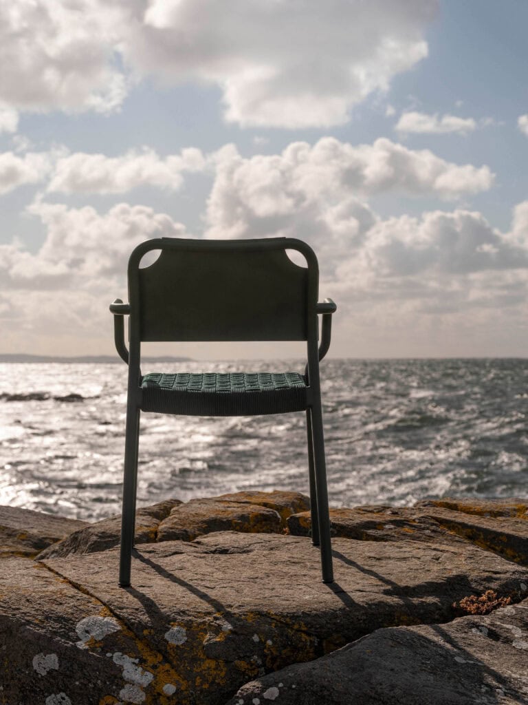Silla con brazos Vind en color Hunter Green mirando al mar